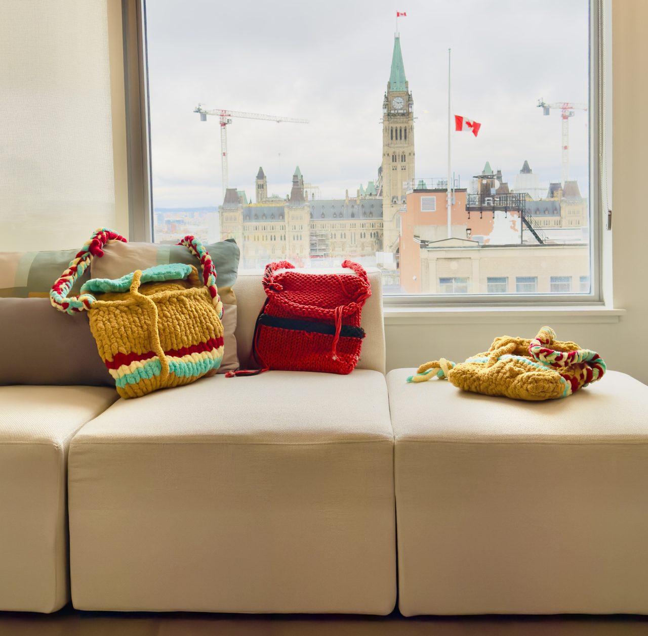 Two hand-crocheted purses photographed at the Ottawa office with Parliament Hill in the window