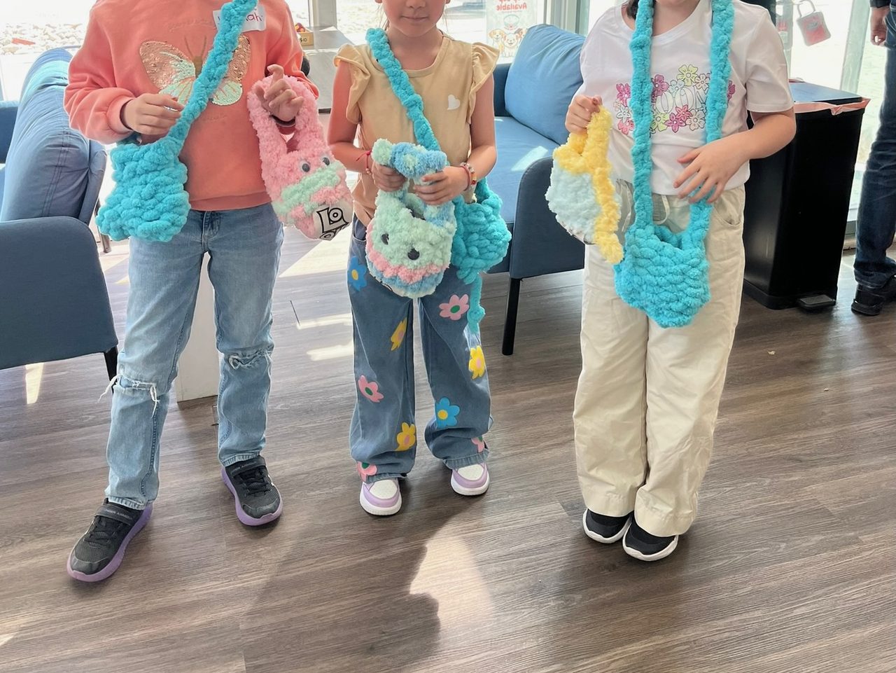 Children wearing the finger-crochet bags they made in a Style Clinic class